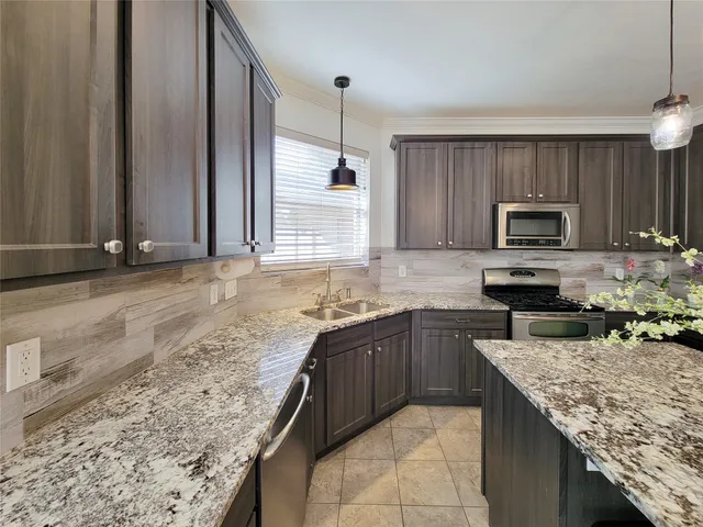 a kitchen with granite countertop a sink and a refrigerator