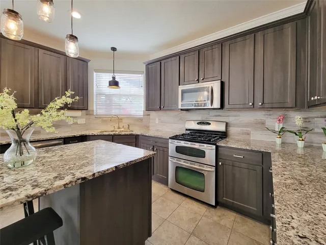 a kitchen with granite countertop wooden cabinets and a granite counter top