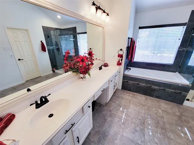 a bathroom with a tub sink mirror and a shower