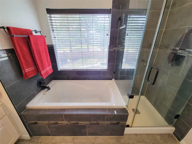 a bathroom with a sink and mirror with bathtub