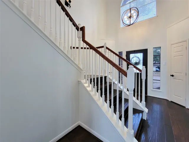 a view of staircase with wooden floor and fan
