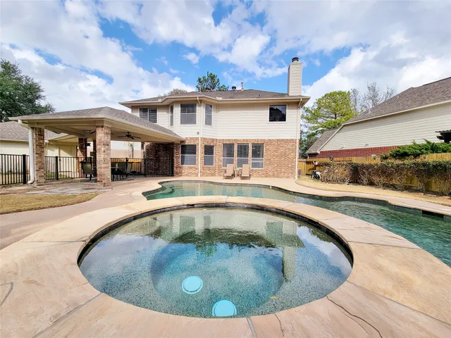 a view of a white house with a swimming pool and a yard