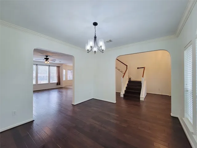 a view of a room with wooden floor staircase and a chandelier