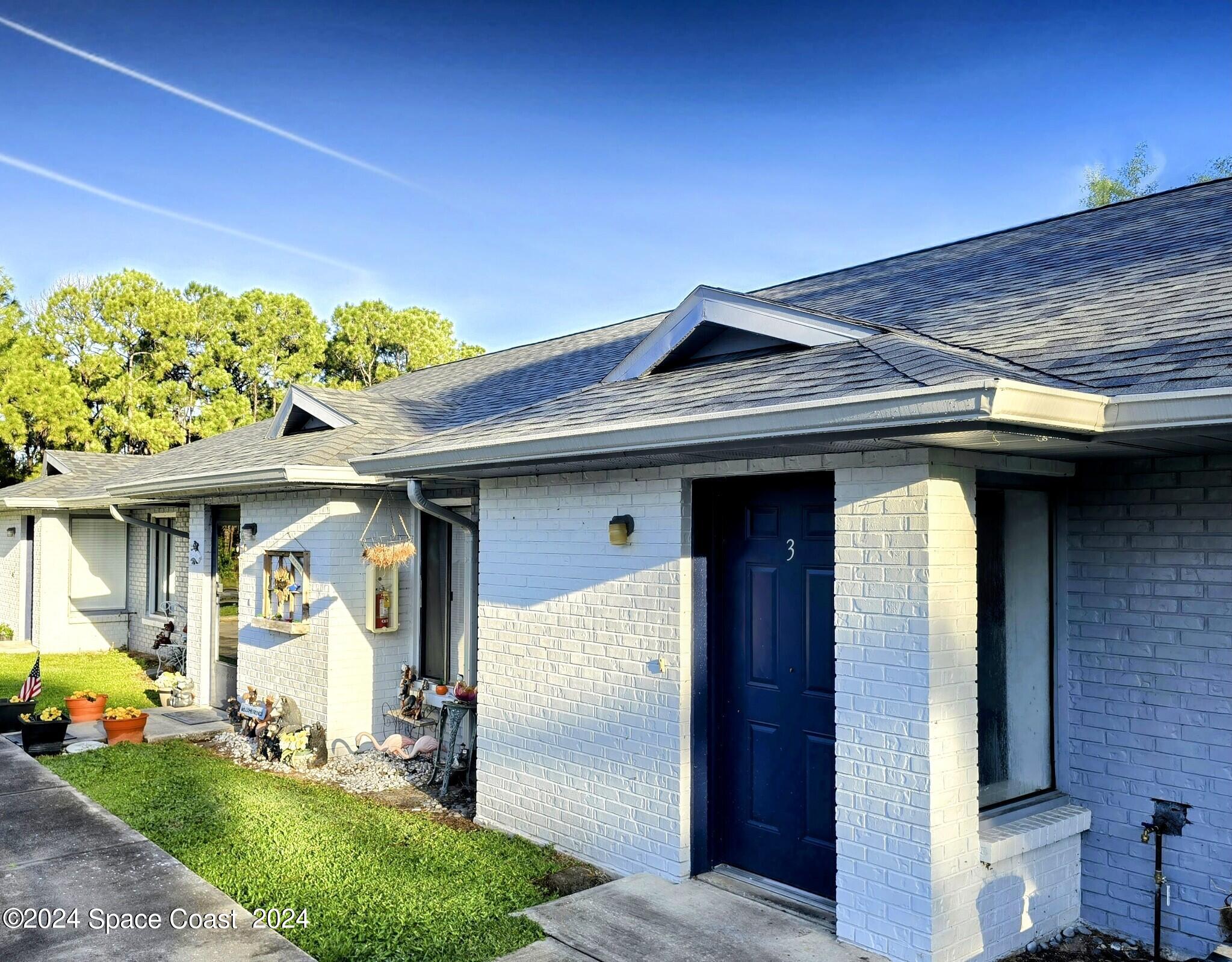 499 Thor Avenue Southeast Palm Bay, FL 32909 - Photo 1 of 4 a view of a wooden door and chair in front of house