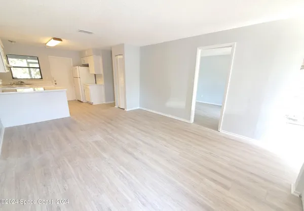 a view of a big room with wooden floor and windows