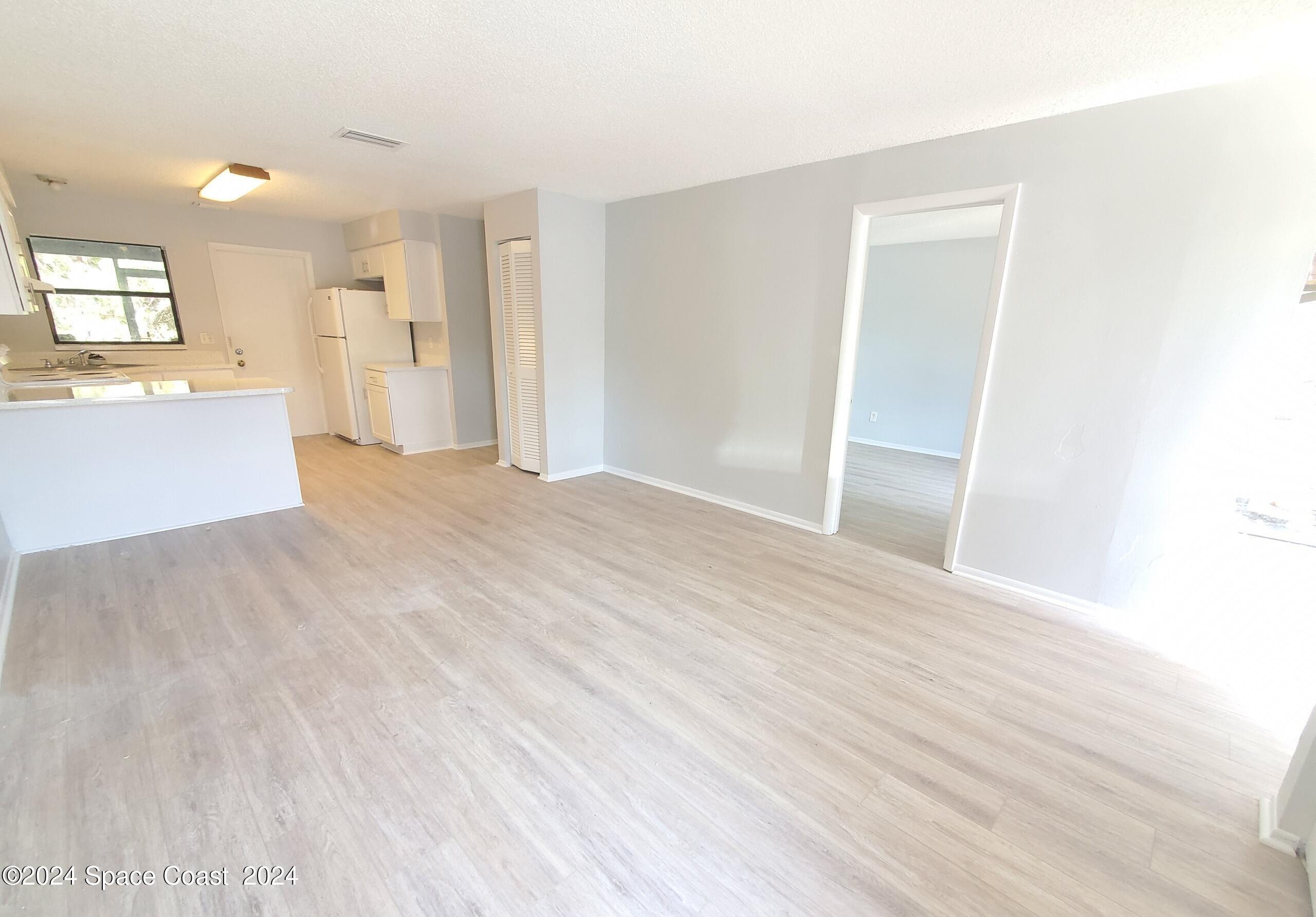 499 Thor Avenue Southeast Palm Bay, FL 32909 - Photo 2 of 4 a view of a big room with wooden floor and windows