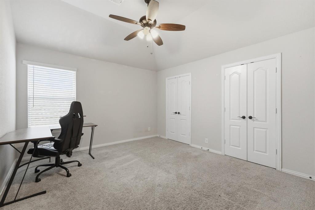 924 Timber Ridge Drive Justin, TX 76247 - Photo 28 of 32 Carpeted room featuring a ceiling fan with light fixture, vaulted ceiling, and multiple paneled doors
