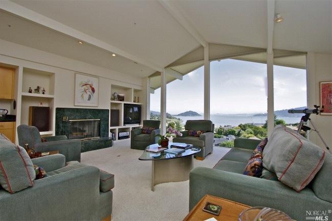 a living room with fireplace furniture and a large window
