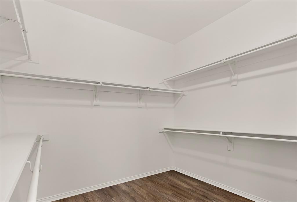 14908 Riverside Drive Little Elm, TX 75068 - Photo 35 of 40 White built-in shelving, white clothes rods, and wood-finish flooring