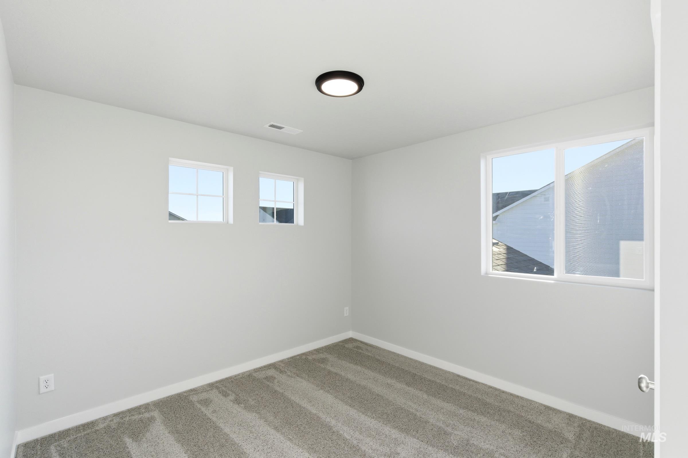 13709 Redway Court Caldwell, ID 83607 - Photo 16 of 28 Bright interior room featuring light gray walls, plush gray carpeting, white trim, and a contemporary ceiling light fixture
