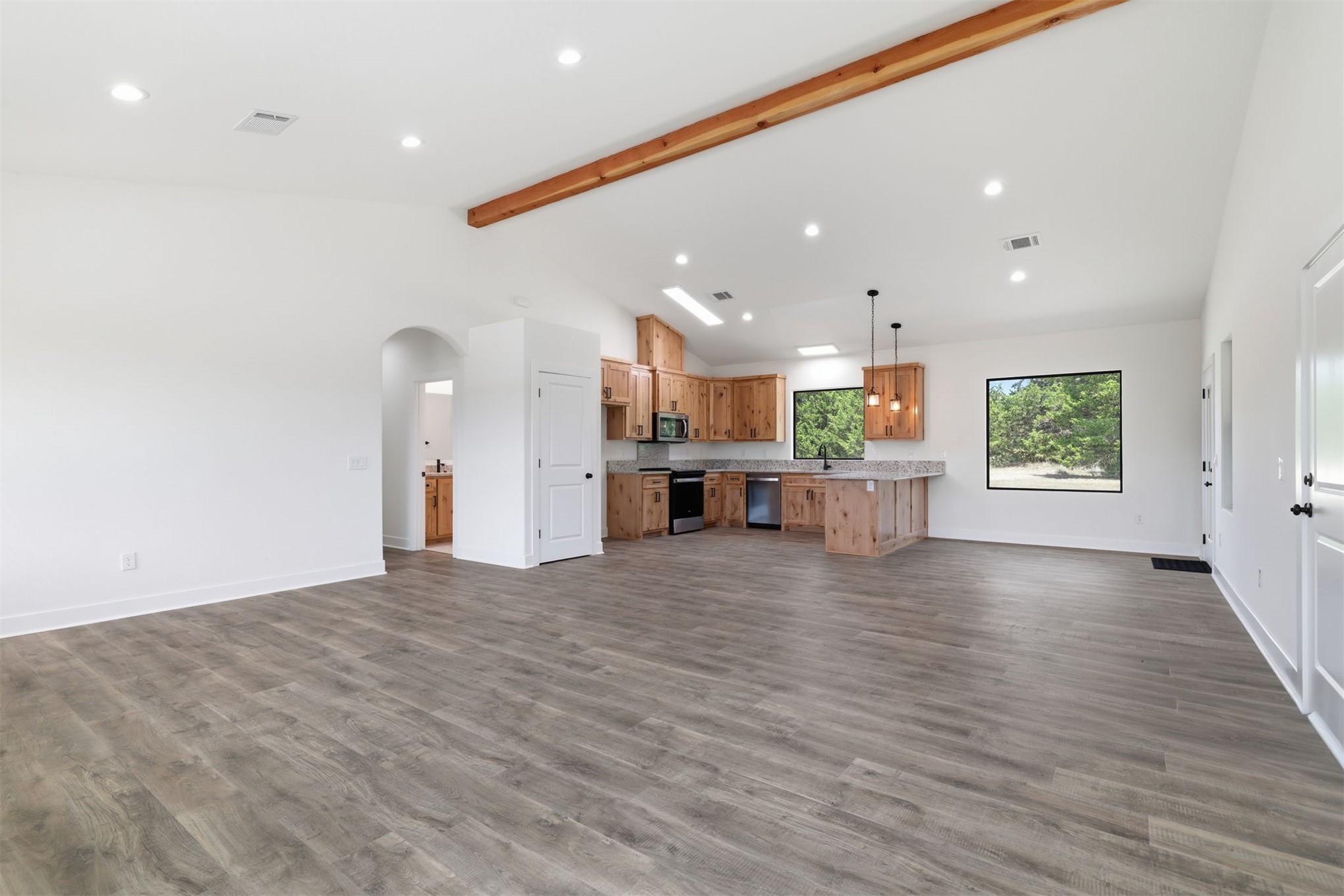 63 Deerfield Road Colbert, OK 74733 - Photo 6 of 33 Open-concept living space featuring wood-finish flooring, recessed lighting, and a vaulted ceiling with exposed wood beam