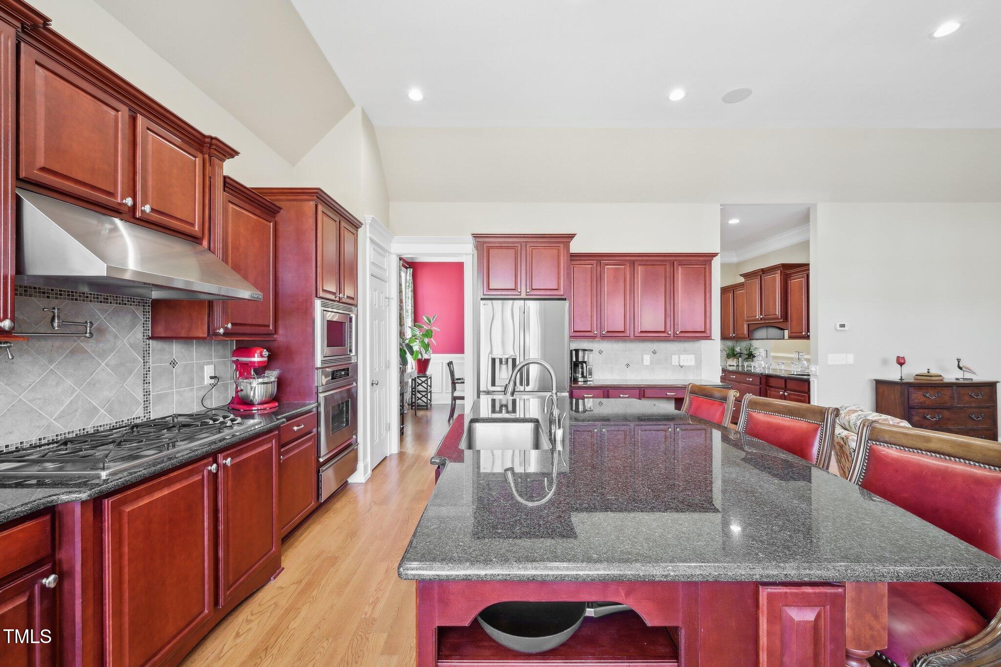 301 Kinsale Drive Durham, NC 27707 - Photo 20 of 68 a kitchen with kitchen island granite countertop a sink stove and wooden cabinets