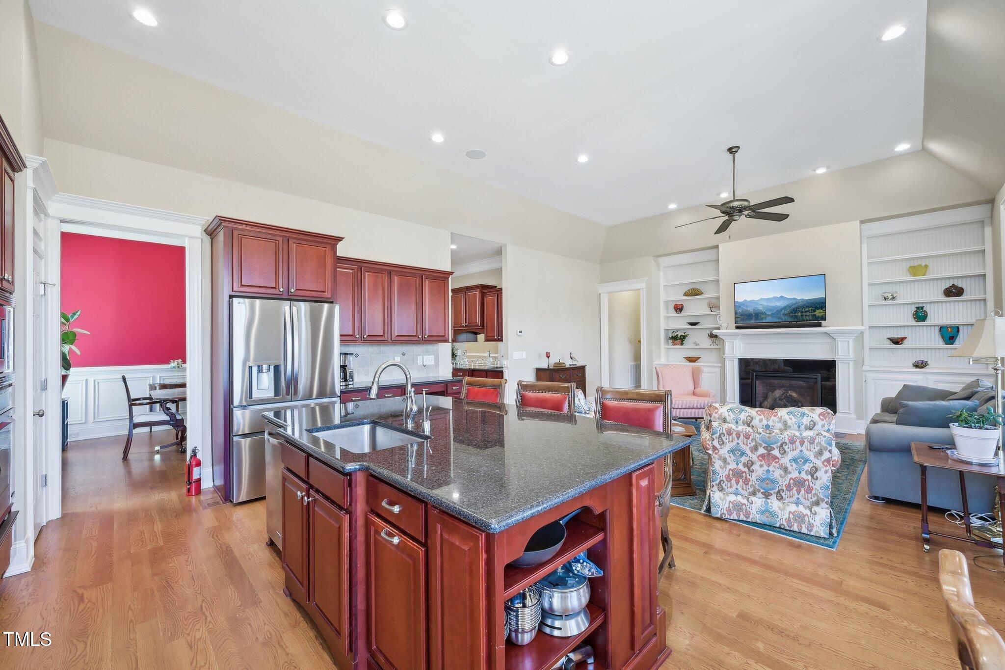 301 Kinsale Drive Durham, NC 27707 - Photo 21 of 68 a kitchen with stainless steel appliances granite countertop a kitchen island a stove a refrigerator a dining table and chairs with wooden floor