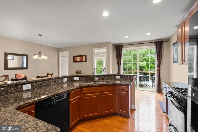 a kitchen with stainless steel appliances granite countertop a sink stove and cabinets