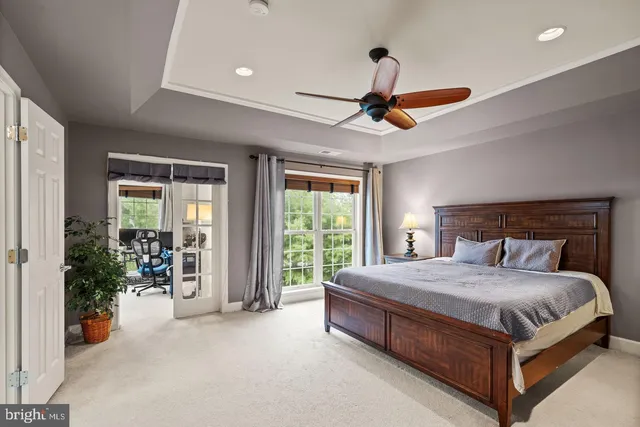 a bedroom with a bed and large windows