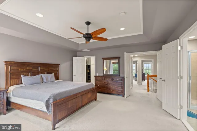 a spacious bedroom with a large bed and a chandelier