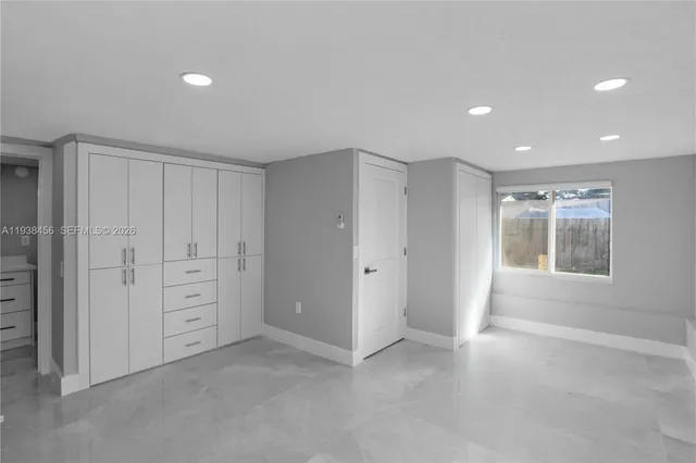 an empty room with windows and closet