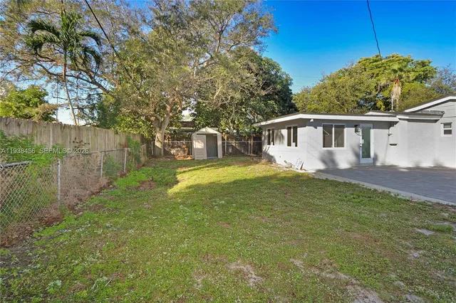 a view of a house with backyard and sitting area