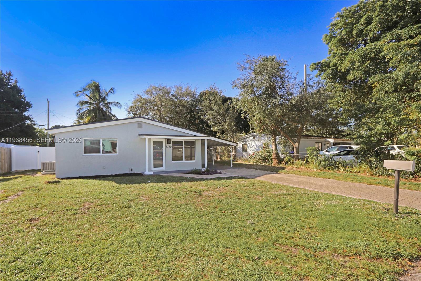 5730 Greene Street Hollywood, FL 33021 - Photo 24 of 27 a backyard of a house with table and chairs under an umbrella