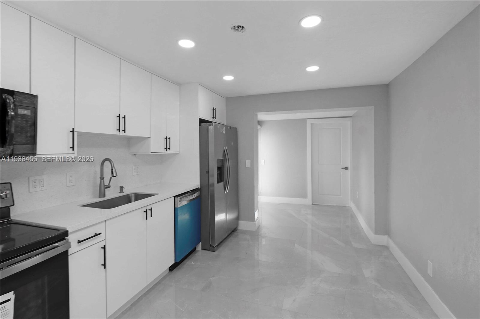 5730 Greene Street Hollywood, FL 33021 - Photo 8 of 27 a kitchen with stainless steel appliances granite countertop a refrigerator a sink a stove a microwave and white cabinets