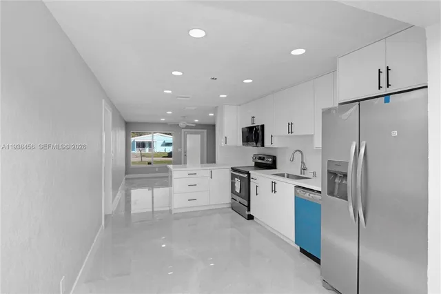 a kitchen with white cabinets and stainless steel appliances