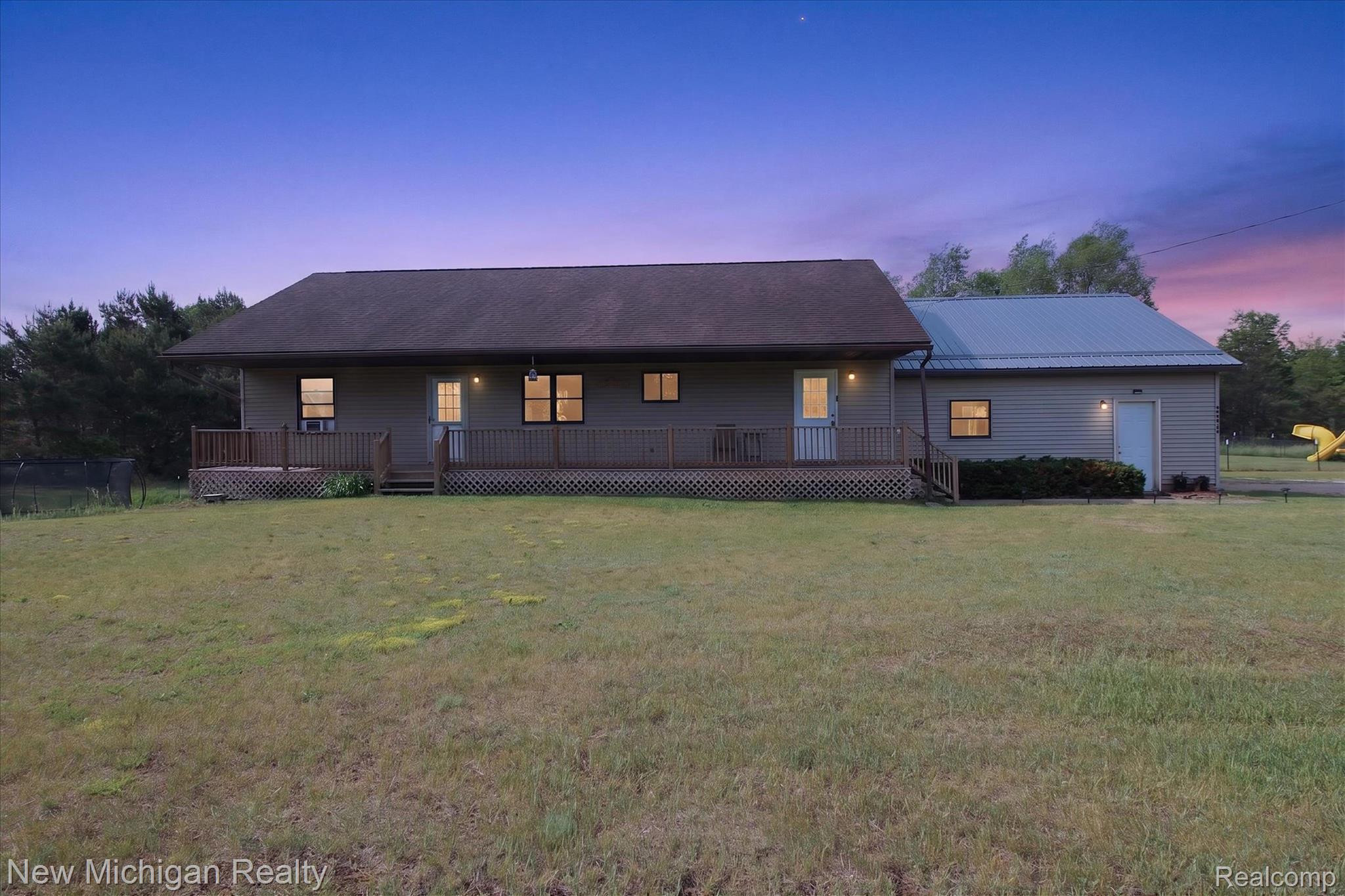 Ranch-style exterior featuring a covered front porch with lattice detailing and a separate attached building with a metal roof