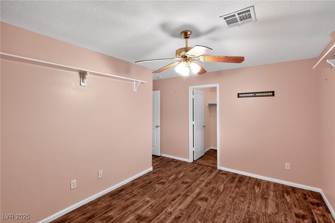 957 Diamond Circle Mesquite, NV 89027 - Photo 20 of 32 Unfurnished bedroom with dark wood-type flooring, ceiling fan, and a textured ceiling