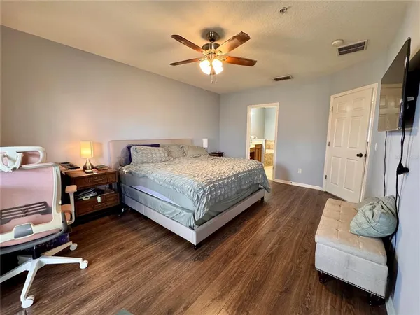 a spacious bedroom with a bed and a flat screen tv