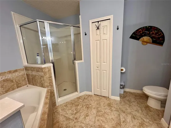 a bathroom with a sink a toilet a mirror and shower