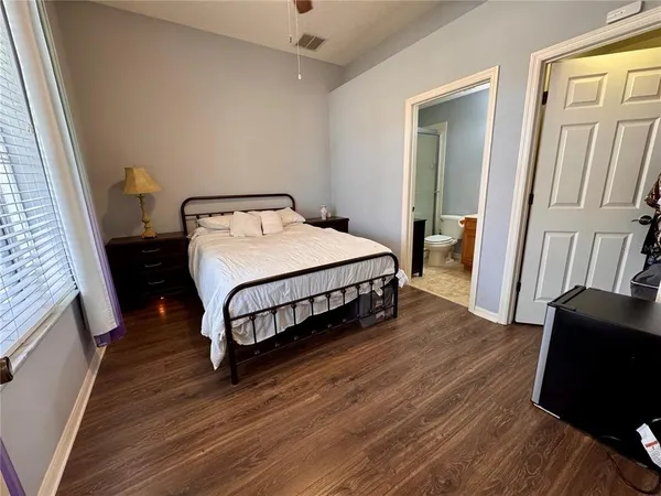 a bedroom with a bed and wooden floor