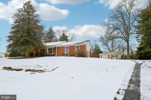 a view of house with yard and trees in the background