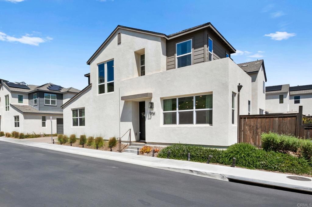1751 Whitmore Loop Chula Vista, CA 91913 - Photo 3 of 44 a front view of a house with a garden and garage