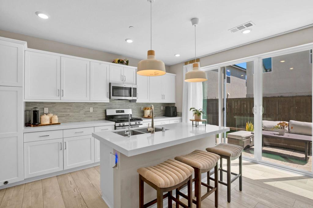 1751 Whitmore Loop Chula Vista, CA 91913 - Photo 4 of 44 a kitchen with a stove a sink a dining table and chairs