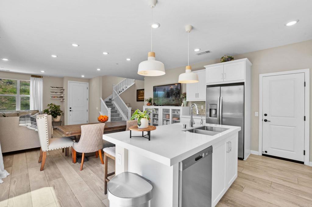 1751 Whitmore Loop Chula Vista, CA 91913 - Photo 6 of 44 a living room with stainless steel appliances kitchen island granite countertop a table chairs and a refrigerator