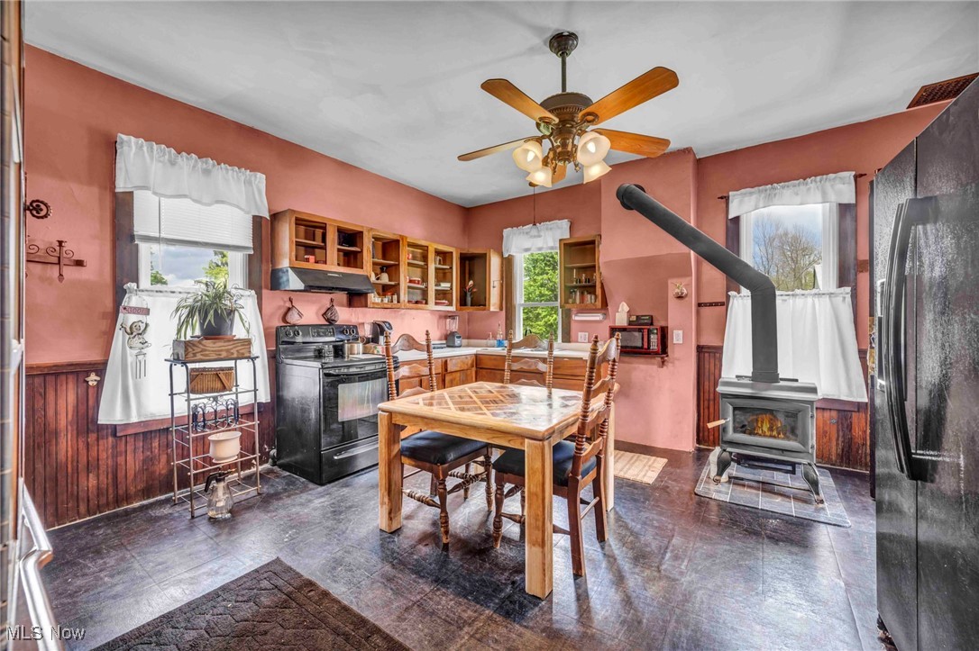 6873 Nichols Road Windham, OH 44288 - Photo 11 of 33 Dining room featuring a wood stove and a ceiling fan
