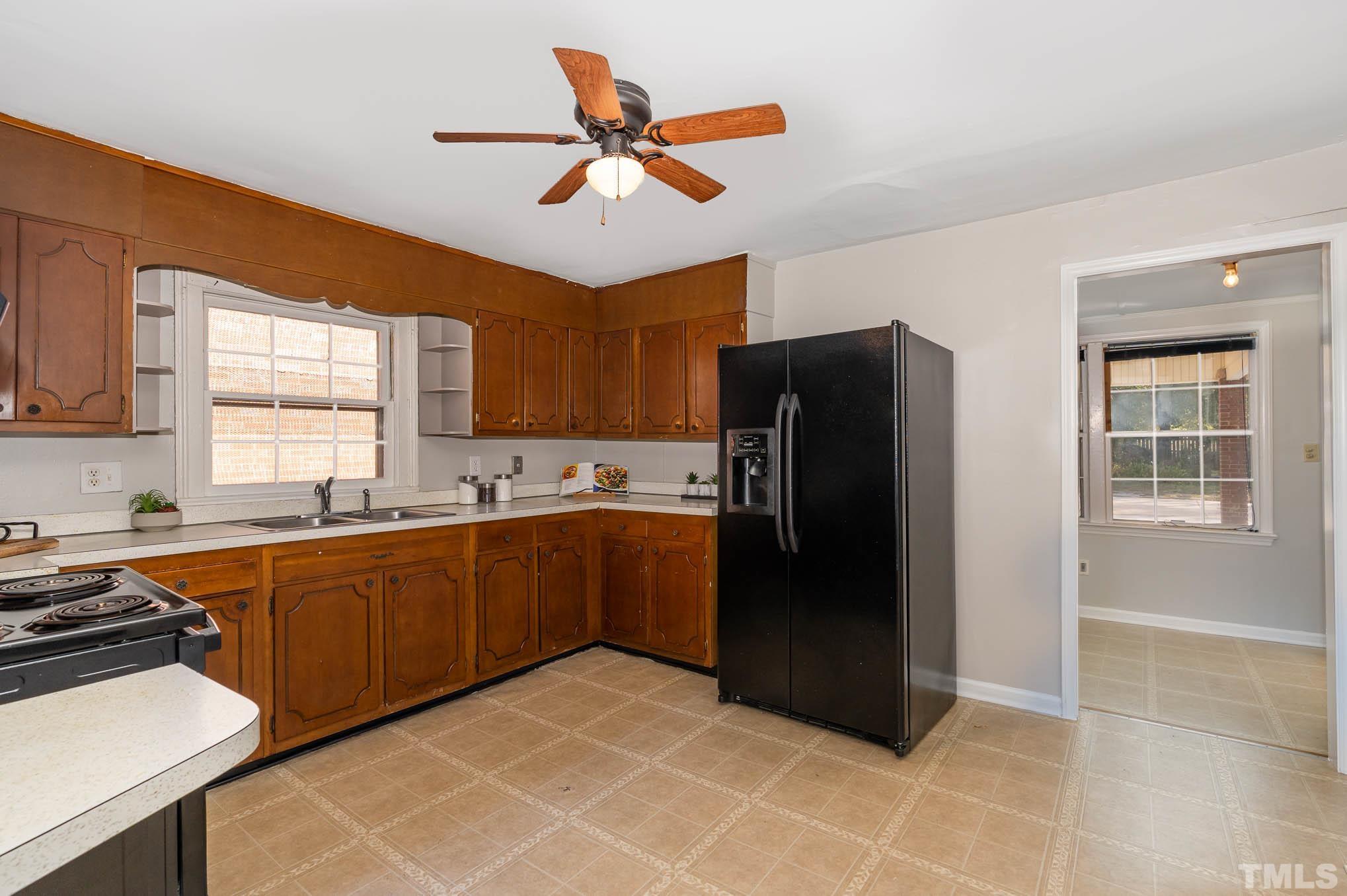 1415 Garner Road Raleigh, NC 27610 - Photo 11 of 15 a kitchen with stainless steel appliances granite countertop a refrigerator a sink a stove with wooden cabinets and a window