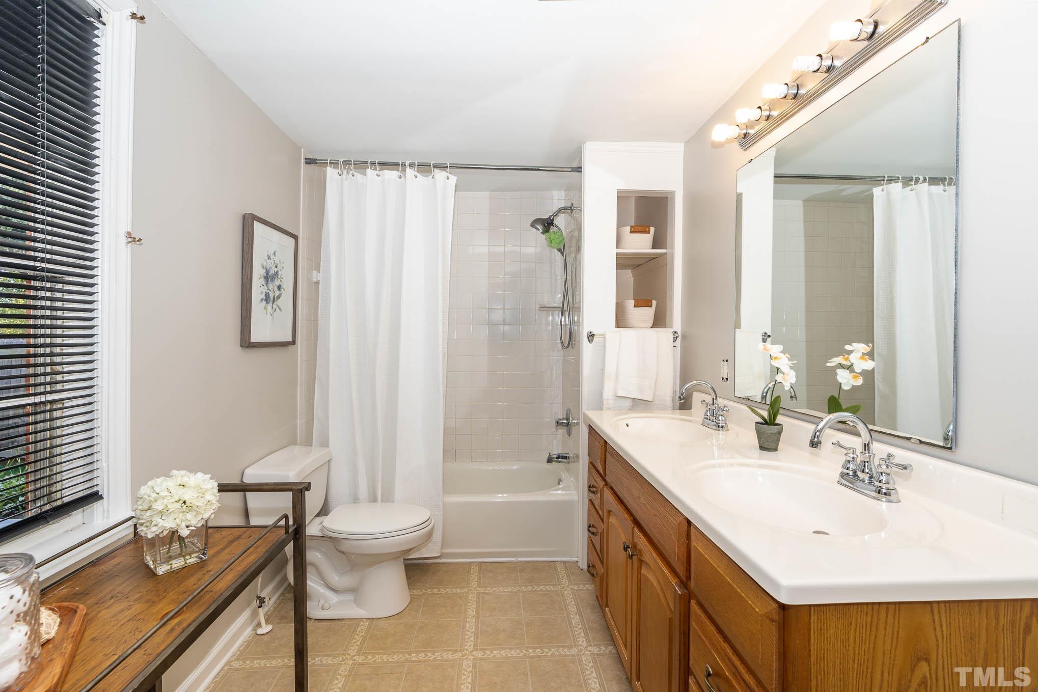 1415 Garner Road Raleigh, NC 27610 - Photo 13 of 15 a bathroom with a double vanity sink toilet and shower