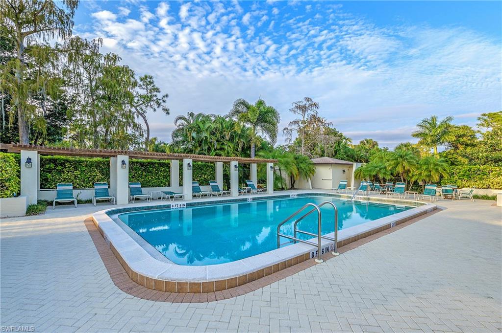1007 Pine Isle Lane, Unit 1007 Naples, FL 34112 - Photo 18 of 20 a view of a swimming pool with an outdoor seating