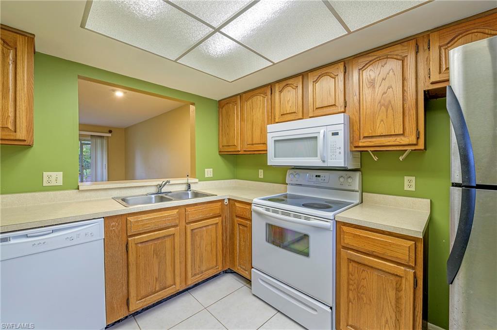 1007 Pine Isle Lane, Unit 1007 Naples, FL 34112 - Photo 2 of 20 a kitchen with a sink stove and cabinets