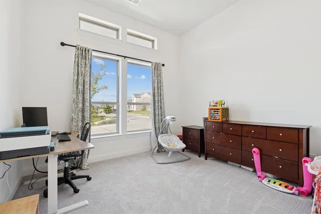a view of a workspace with furniture and a window