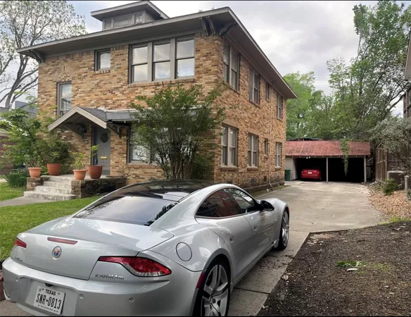 a front view of a house with car parked