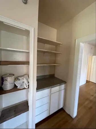 a kitchen with a refrigerator and white cabinets