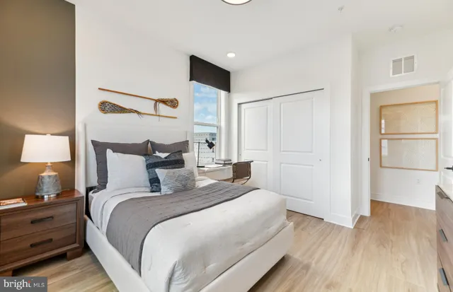 a bedroom with a bed lamps and a large window