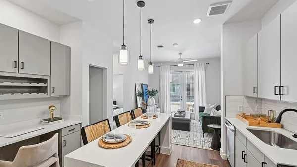 a kitchen with stainless steel appliances kitchen island granite countertop a sink and refrigerator