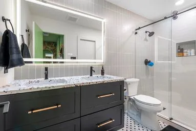 a bathroom with a granite countertop sink toilet and shower