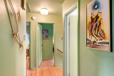 a view of a hallway with wooden floor and door