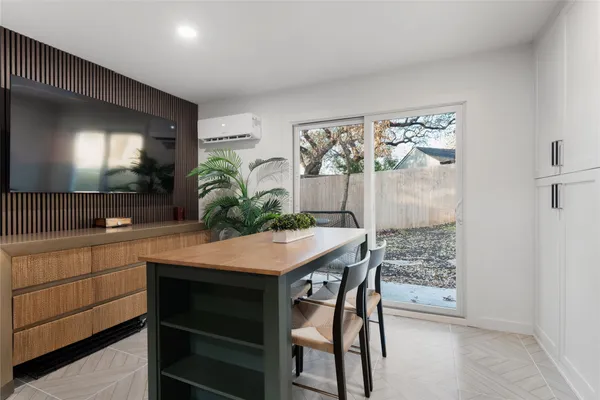 a kitchen with stainless steel appliances kitchen island a table and chairs in it