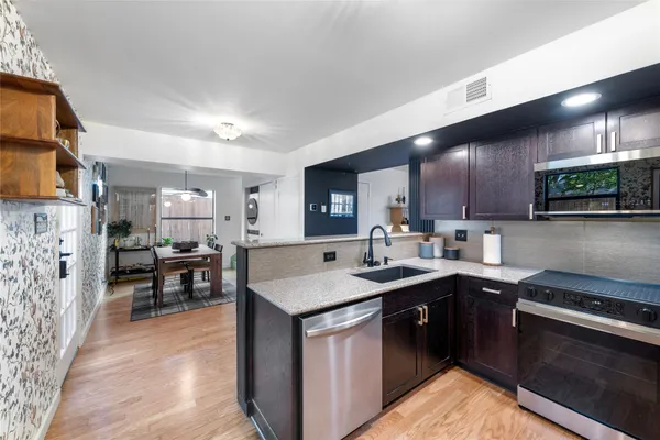 a kitchen with stainless steel appliances granite countertop a sink stove and refrigerator