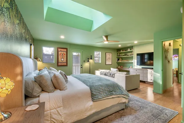 a large bedroom with a bed and wooden floor