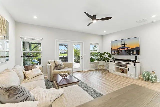 a living room with furniture a window and a flat screen tv